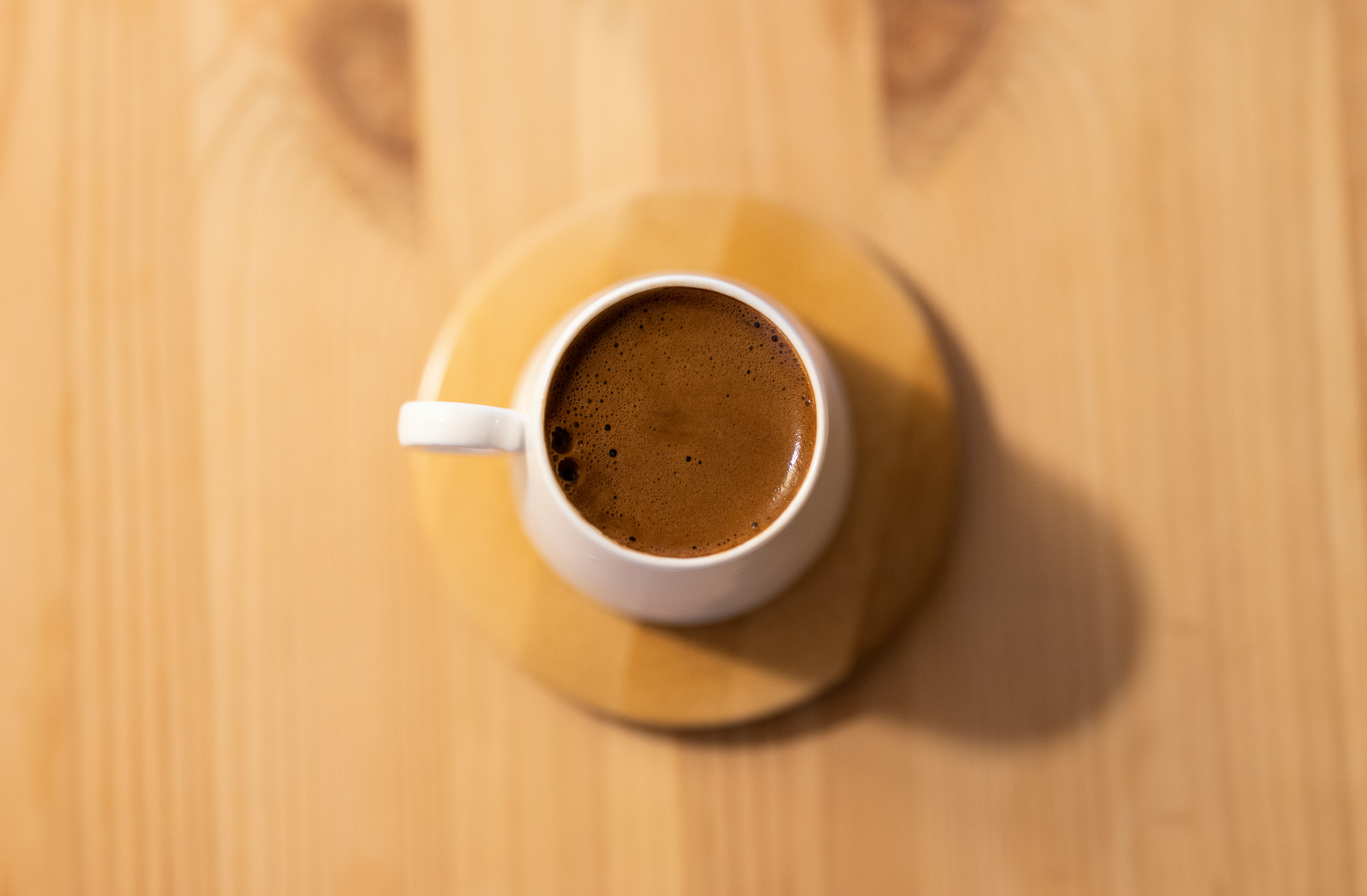 white ceramic mug with brown liquid